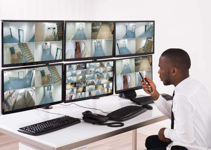 A photo of a person monitoring video alarm monitors.